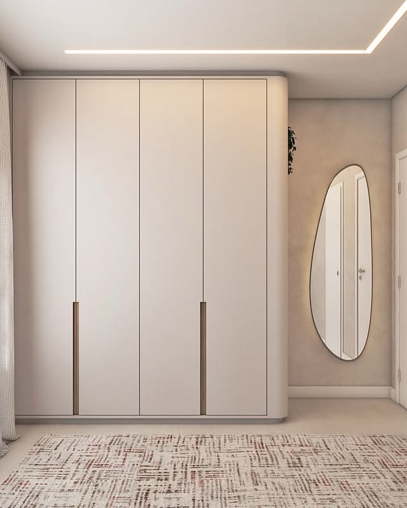 Fitted wardrobe with timber pull handles and a sculptural mirror