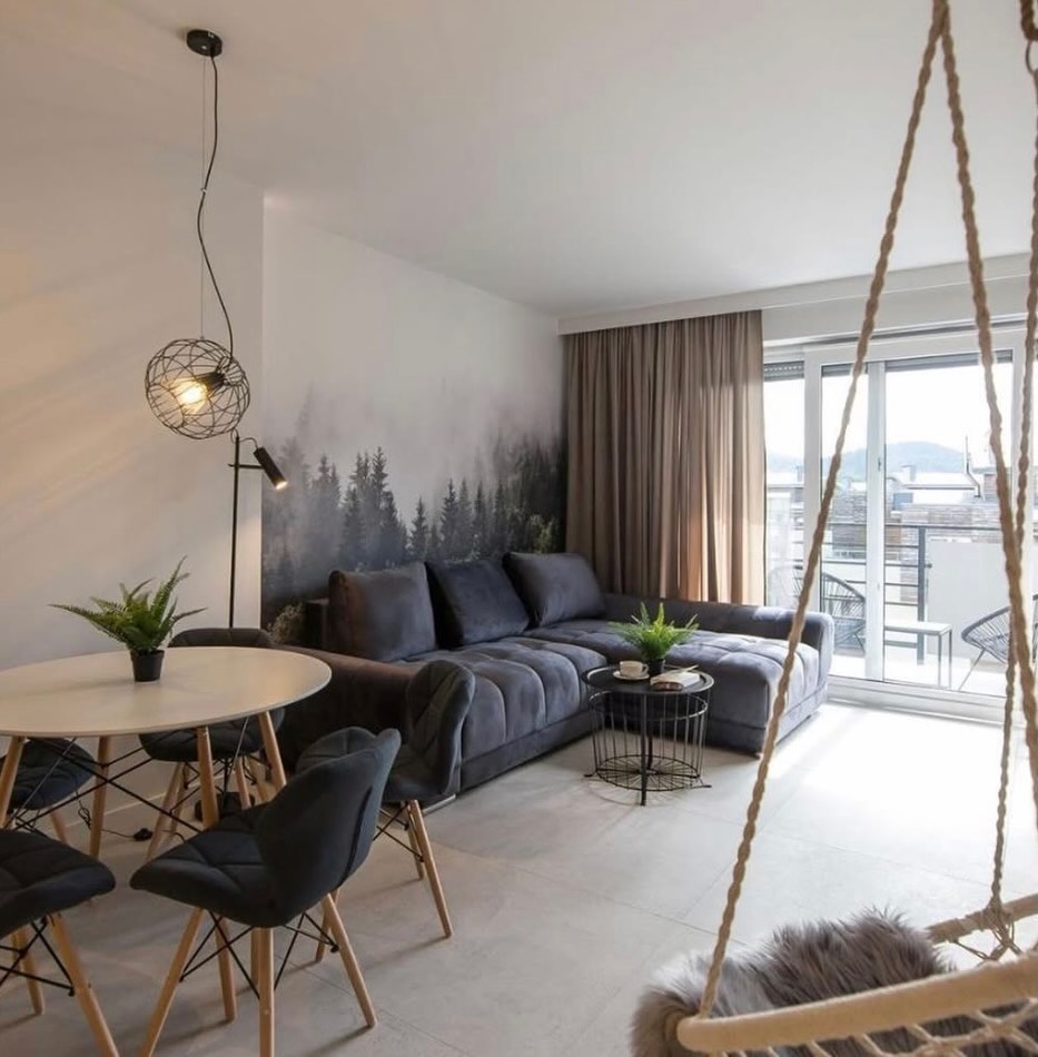 Living area with forest mural, corner sofa and hanging chair